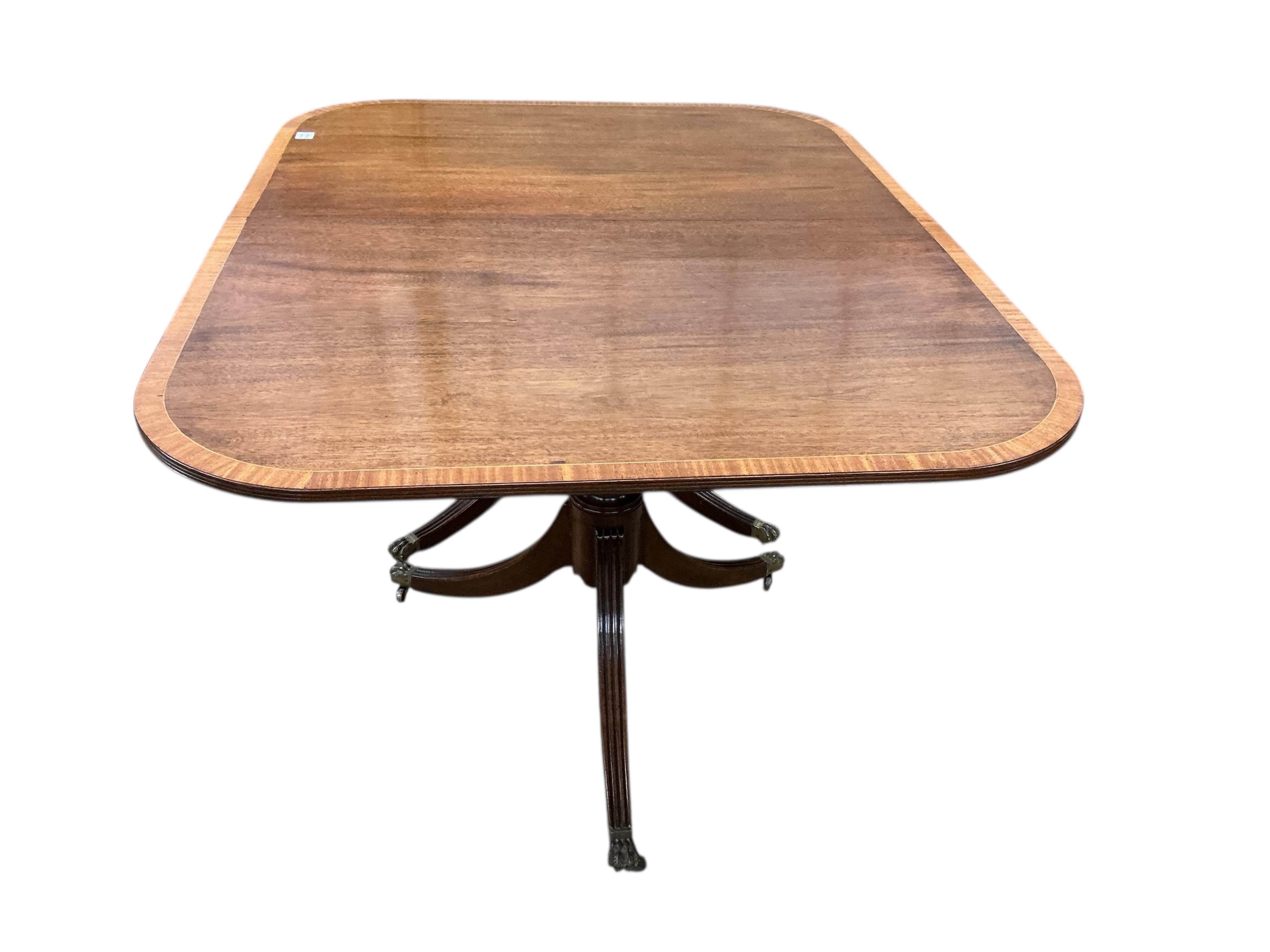 A Regency style mahogany and satinwood banded three pillar dining table, width 320cm extended, two spare leaves, depth 114cm, height 74cm